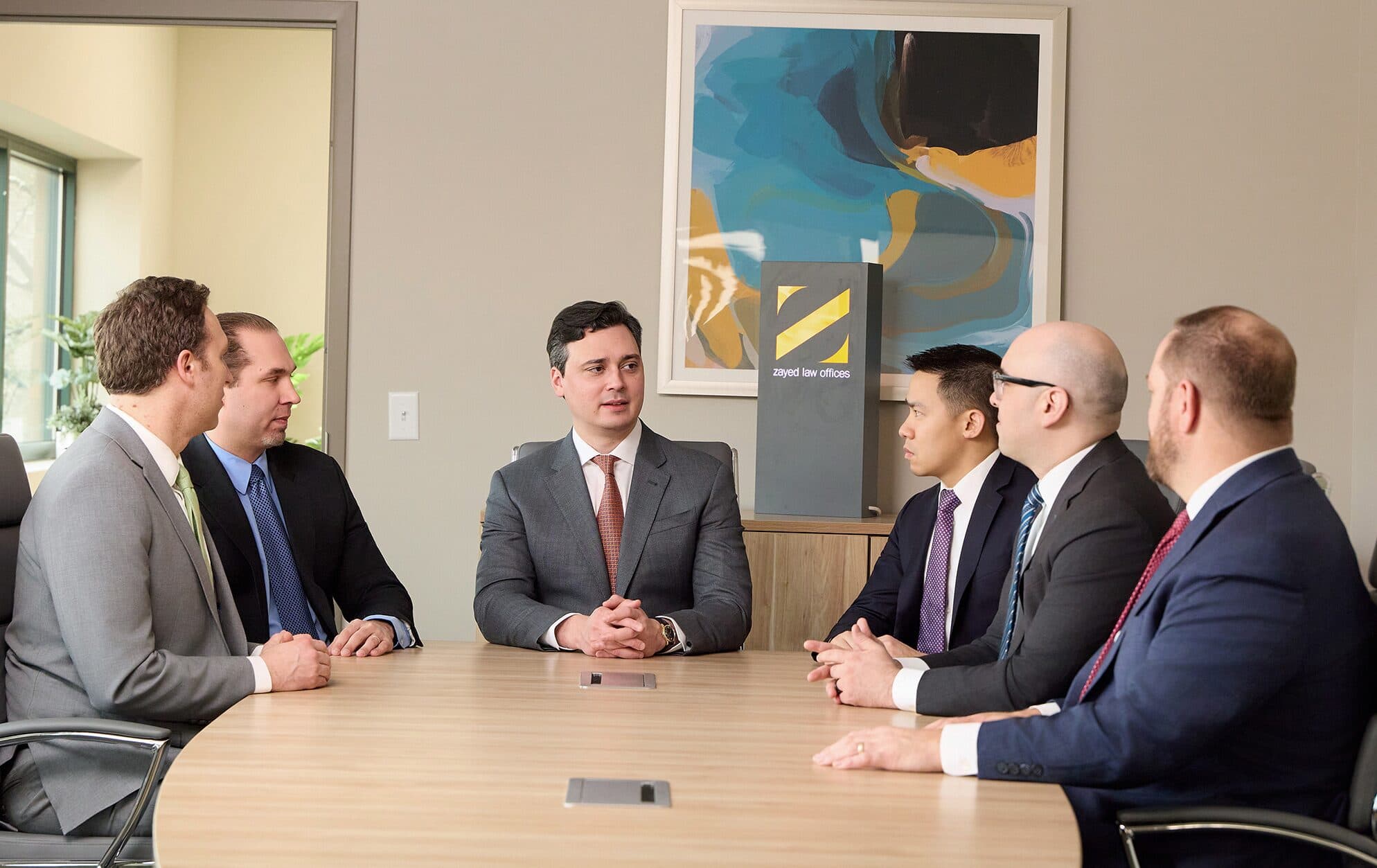 Attorneys of Zayed Law Offices in conference around the firm's boardroom table